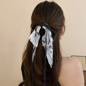 Detail of ribbon hair claw clip featuring ink wash pattern on a satin fabric finish