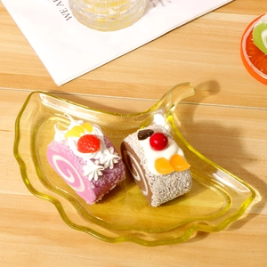 Plateau transparent en forme de feuille de ginkgo avec des faux gâteaux roulés