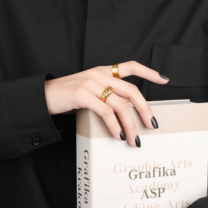 Set di anelli d'oro a torsione stile croissant e a doppio strato su una mano di una modella