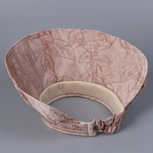 Detail view of pink sun visor with leaf texture and breathable mesh inner lining