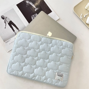 Detail of light blue laptop sleeve featuring 3D cloud patterns and soft textured fabric
