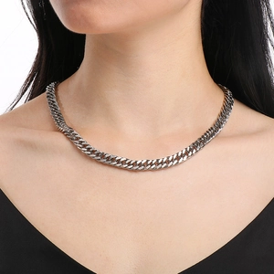 Close-up of silver Cuban link necklace on model's neck showcasing polished finish and texture