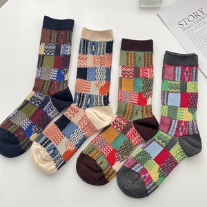 Flat lay of four pairs of vintage style color-block plaid knit socks on white background