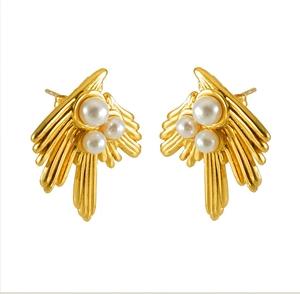 Macro detail of 18K gold plated swallow wing earrings with three elegant white pearls