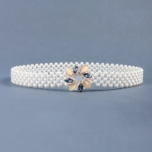 Detail showing white pearl beaded waist belt with a gold flower buckle and colored gemstones