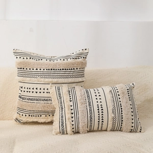 Detail of bohemian tufted cushion covers with black geometric patterns and fringes
