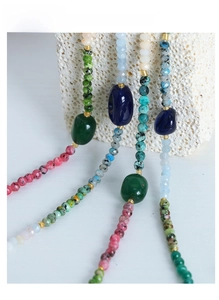 Macro detail of handmade natural stone necklace with green agate and colorful beads