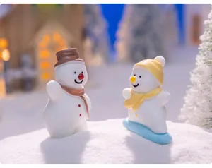 Macro shot of two mini Christmas snowmen figurines with hats and scarves for DIY decor