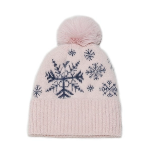 Detail of pink knitted Christmas hat with blue snowflake patterns and a soft pom-pom