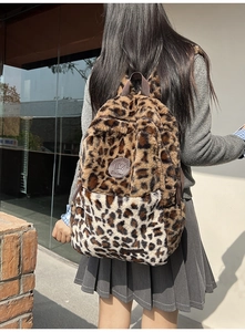 Dettaglio dello zaino in peluche leopardato con logo in pelle e consistenza morbida