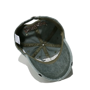Detail of olive green washed denim cap with vintage distressing and metal adjustment buckle