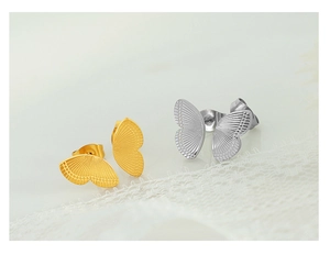 Detailed macro view of butterfly-shaped studs in gold and silver finish on lace