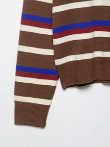 Detailed close-up of multi-color striped knit sweater showing ribbed cuffs and hem texture