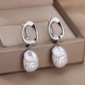 Baroque irregular pearl earrings with silver metal hooks on a brown jewelry box