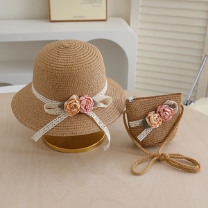 Detail of straw hat and matching bag with delicate lace bow and floral accents