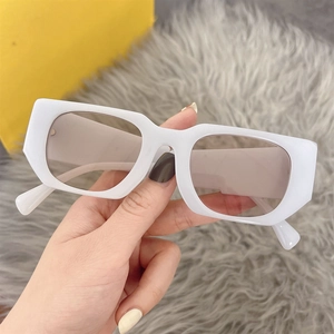 Close-up of white rectangular sunglasses with light brown lenses and wide temples
