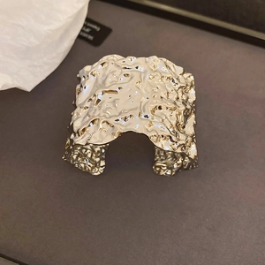 Macro detail of silver geometric wrinkled cuff bracelet with a modern melt texture finish