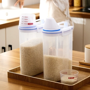 Transparent plastic airtight grain storage container with blue handle and measuring cup lid