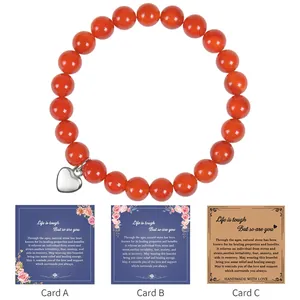 Detail of red agate beaded bracelet with heart charm and inspirational gift cards