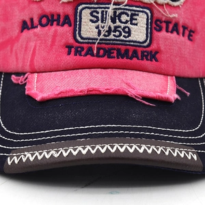 Macro shot of embroidered baseball cap with distressed edges and Aloha State lettering