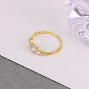 Detailed close-up of a luxury gold ring with sparkling clear stones and curved pavé setting