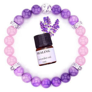 Detail view of healing yoga bracelet with lavender oil bottle and purple stone beads