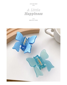 Detail of blue and translucent green butterfly hair claws with glossy resin finish