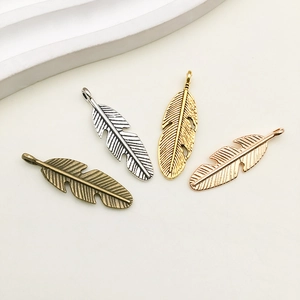 Detail view of leaf wing alloy pendants in bronze, silver, gold, and rose gold finishes