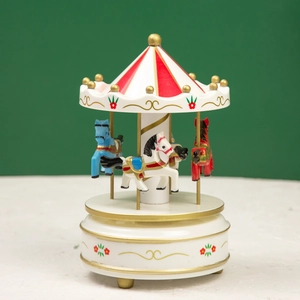 Detailed view of the carousel music box with hand-painted horses in red white and gold