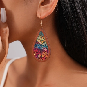 Close-up of a teardrop wood acrylic earring with bohemian floral pattern on a model