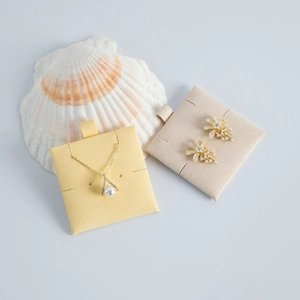 Close-up of pearl jewelry set with gold floral earrings and necklace on white shell