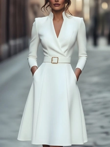 Detail of white V-neck dress with golden buckle belt and practical side pockets