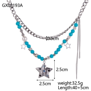Detail of bohemian layered necklace with turquoise beads, stars, and pearls on white background