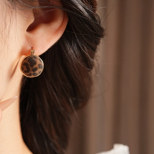 Close-up of vintage leopard print leopard velvet circular earrings on female model
