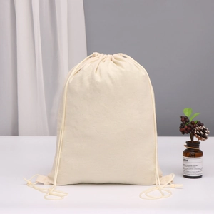 Minimalist cream cotton linen drawstring bag for jewelry storage on a white table