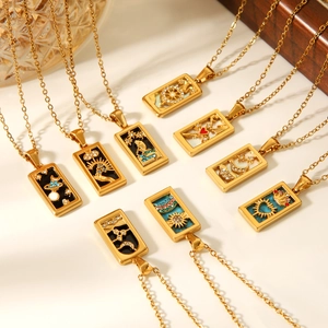 Dettaglio di ciondoli tarocchi placcati in oro 18k con smalto colorato e cristalli