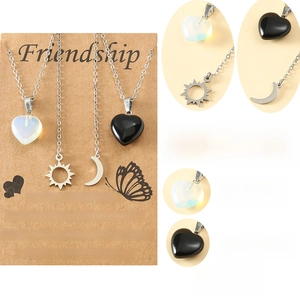 Detailed view of sun and moon heart necklaces with natural stones and steel chain