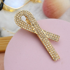 Vue détaillée d'une barrette note de musique dorée ornée de strass brillants et de perles