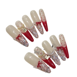 Elegant red and white handmade press-on nails with bowknot and gold charms