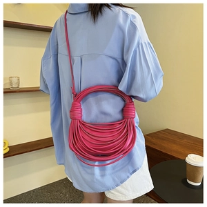 Dettaglio ravvicinato della borsa a mano in corda intrecciata rosa rossa con nodi