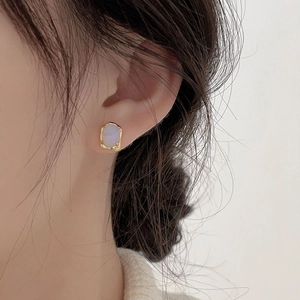 Close-up of minimalist irregular oval gold earrings with soft lavender opal center stones