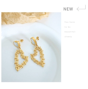 Detail of gold heart earrings with mother of pearl inlay and woven texture design