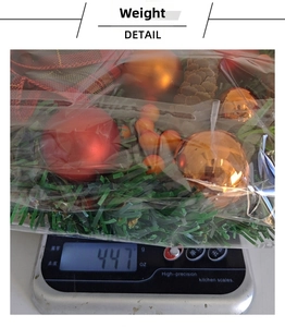 Detailed weight measurement showing Christmas wreath with red ornaments on a scale