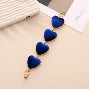 Close-up of blue velvet heart charms with golden metal edges and durable lobster clasps