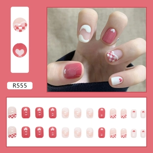 Detail van roze geruite kunstnagels met hartpatronen en golvende kunststijl