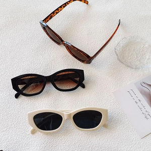 Retro cat-eye sunglasses for women in tortoiseshell, black and cream on white background