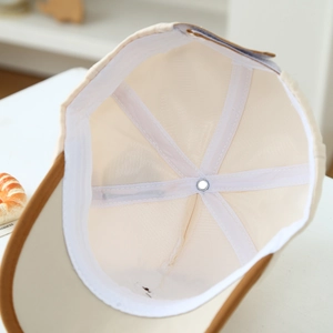 Detail view of the breathable mesh lining and reinforced seams inside the beige baby cap