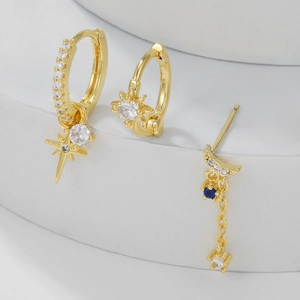 Detailed shot of celestial gold earring set with blue stones and starry fringe chains