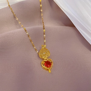Golden titanium heart locket with red gemstone on elegant pink silk and white gauze