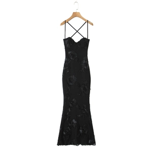 Close-up of 3D floral appliqués on a black bodycon dress with intricate lace-up back